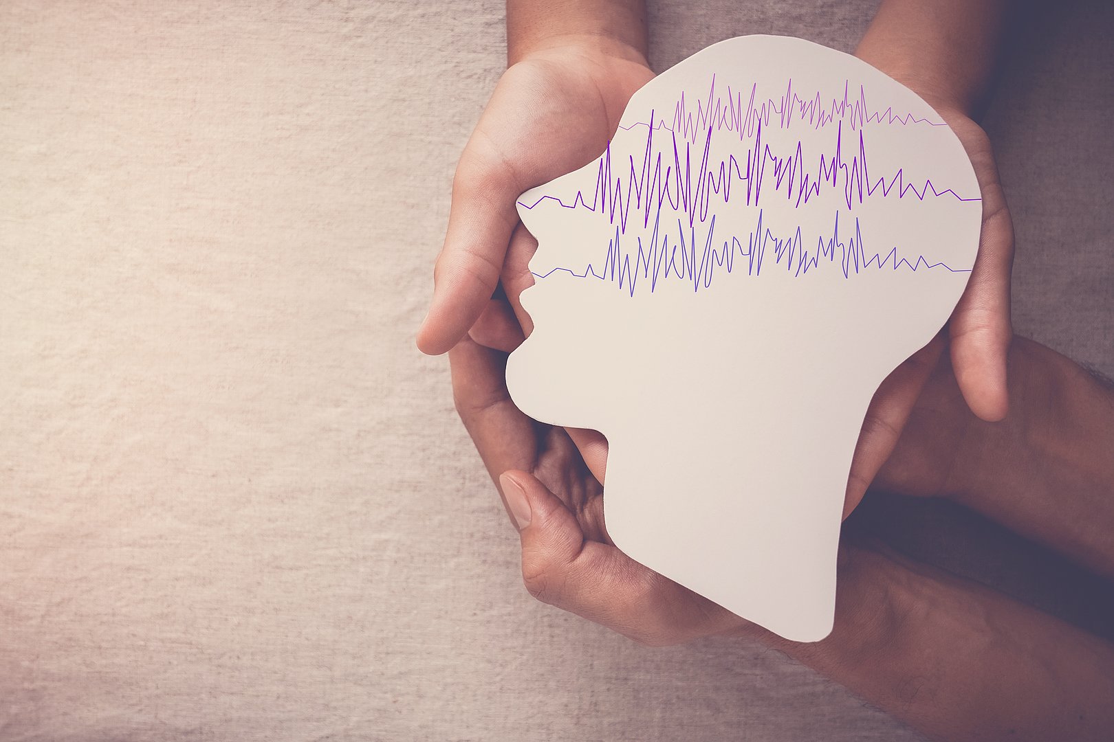 Adult and child hands holding encephalography brain paper cutout, Epilepsy awareness, seizure disorder, mental health concept